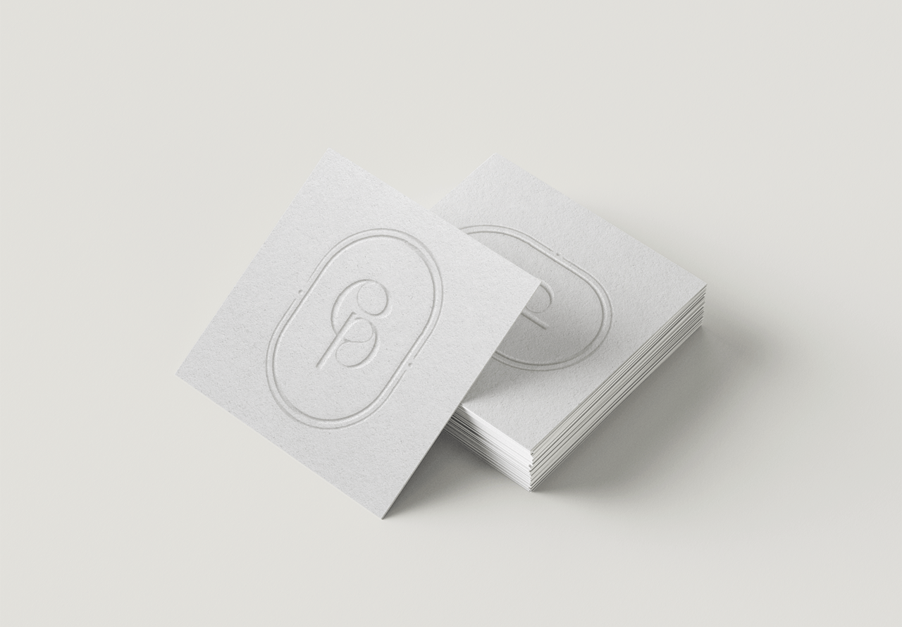 Een horizontale mock-up van witte letterpress visitekaartjes met een sierlijk logo ontwerp voor Copiene.